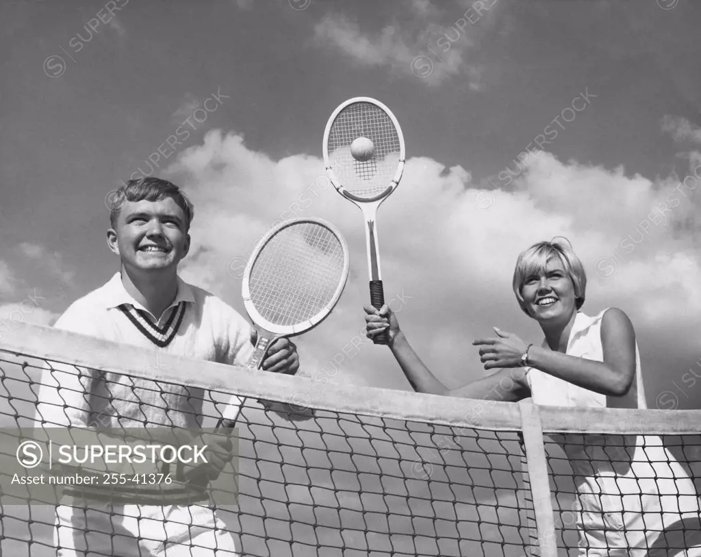 Low angle view of young couple playing tennis
