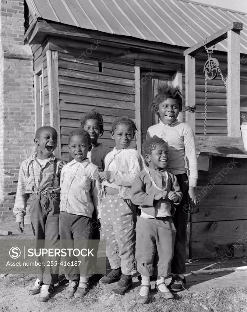 Six children standing outside house