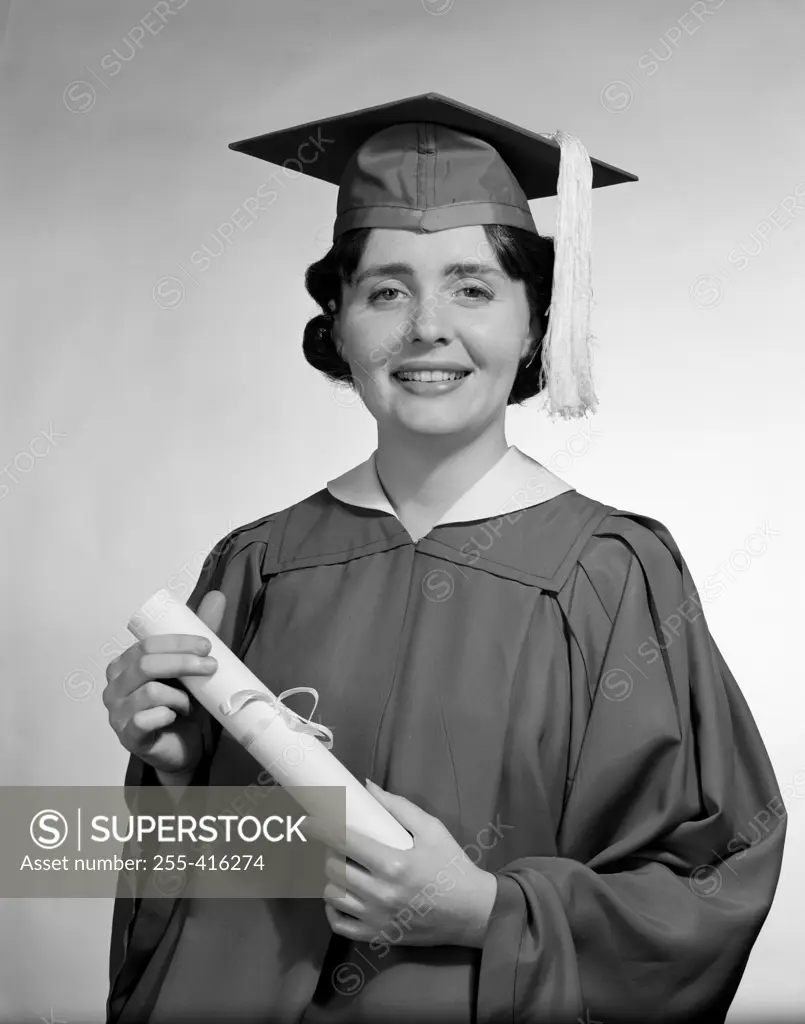 Woman wearing graduation gown holding diploma