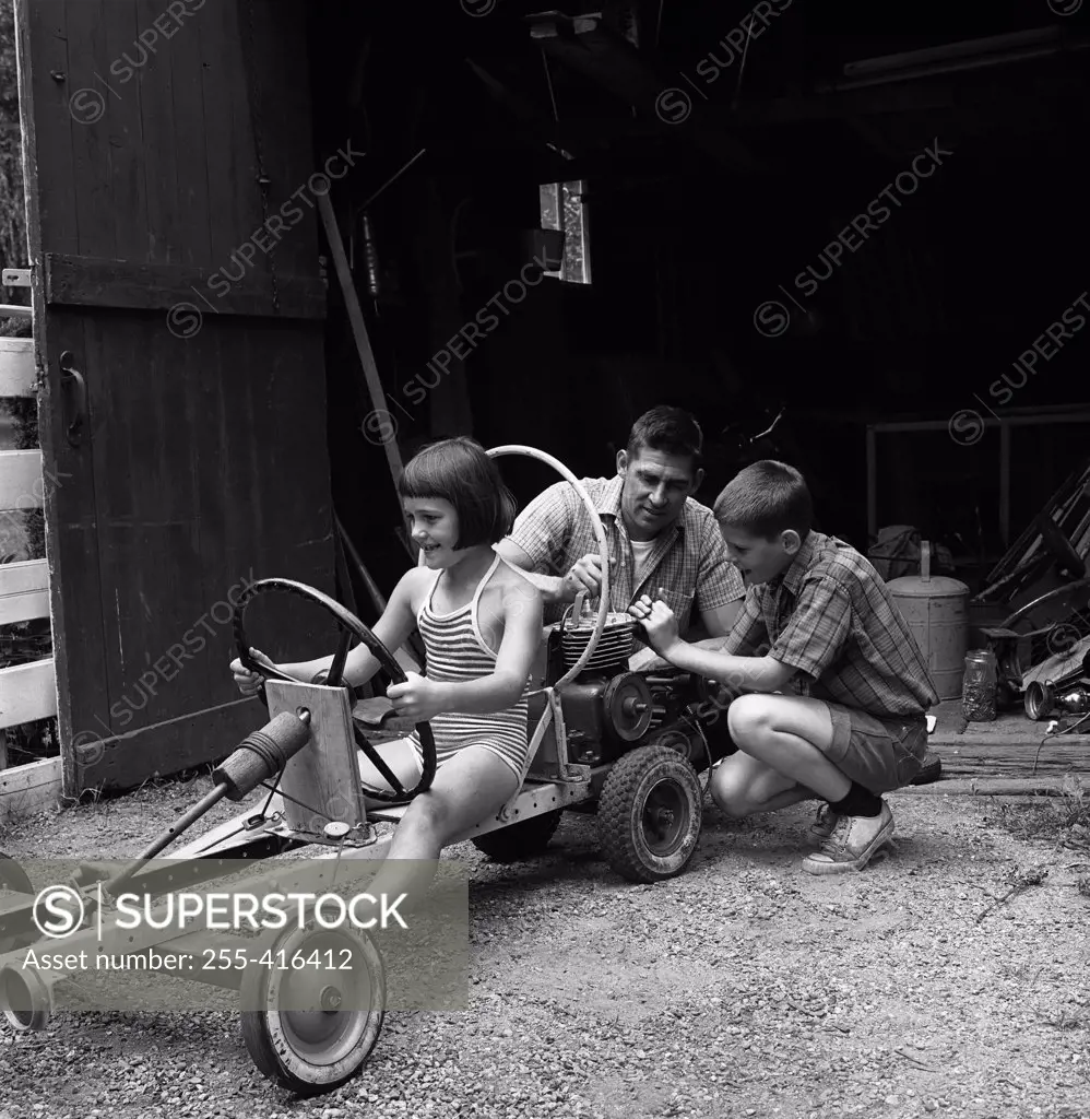 Father with children playing with  funny vehicle