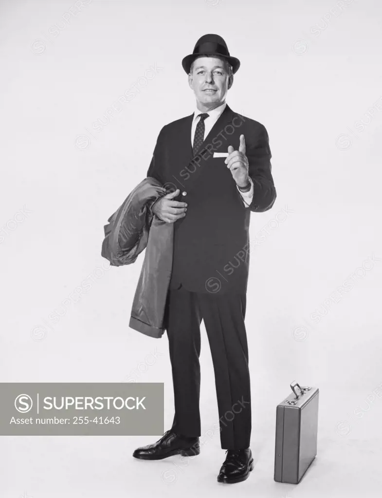 Portrait of a businessman pointing upwards