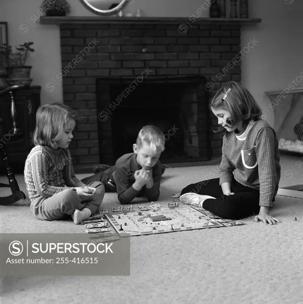 Children  playing board game on carpet