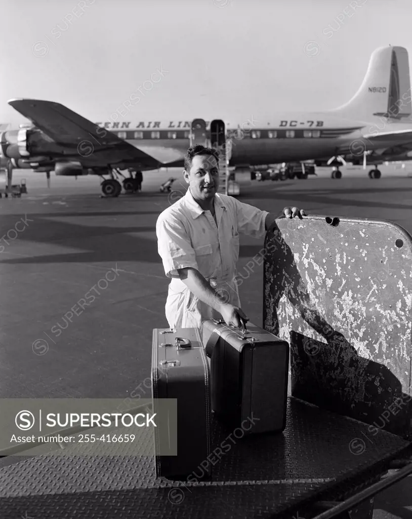 Ground staff man at airport with suitcase