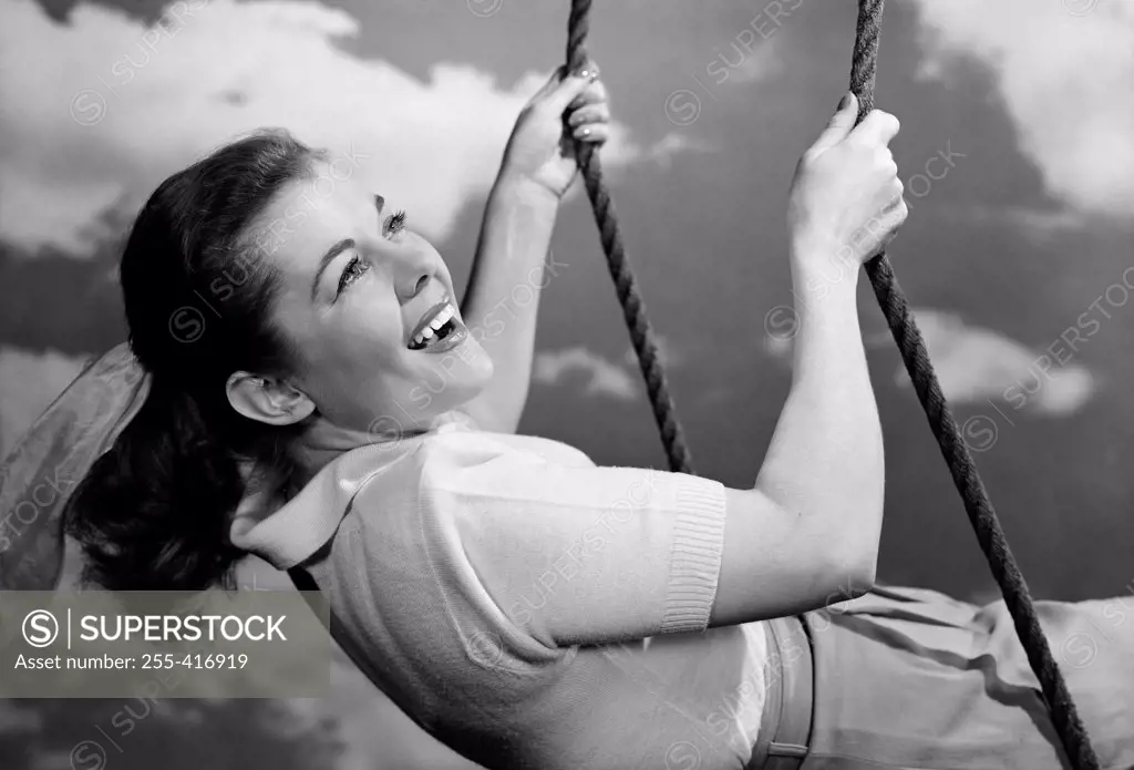 Young woman swinging and laughing