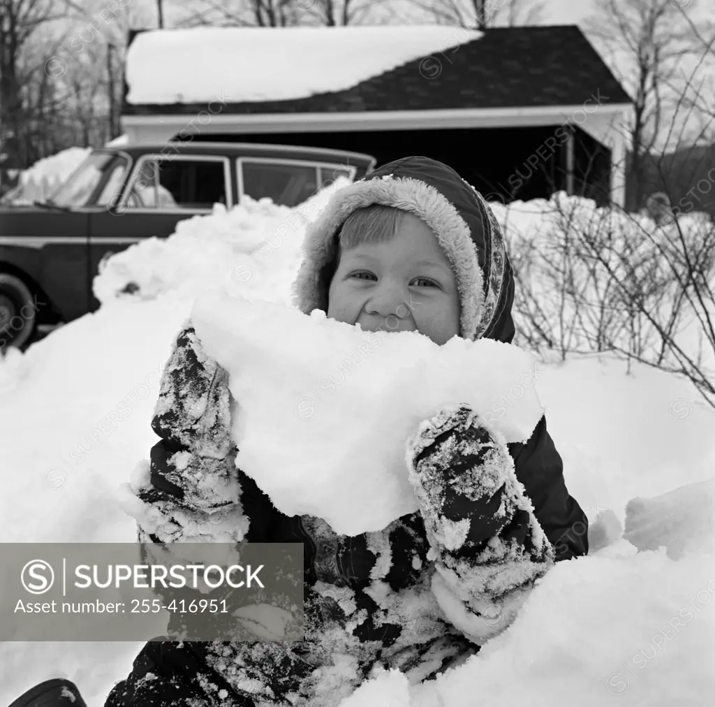 Girl holding pile of snow, portrait