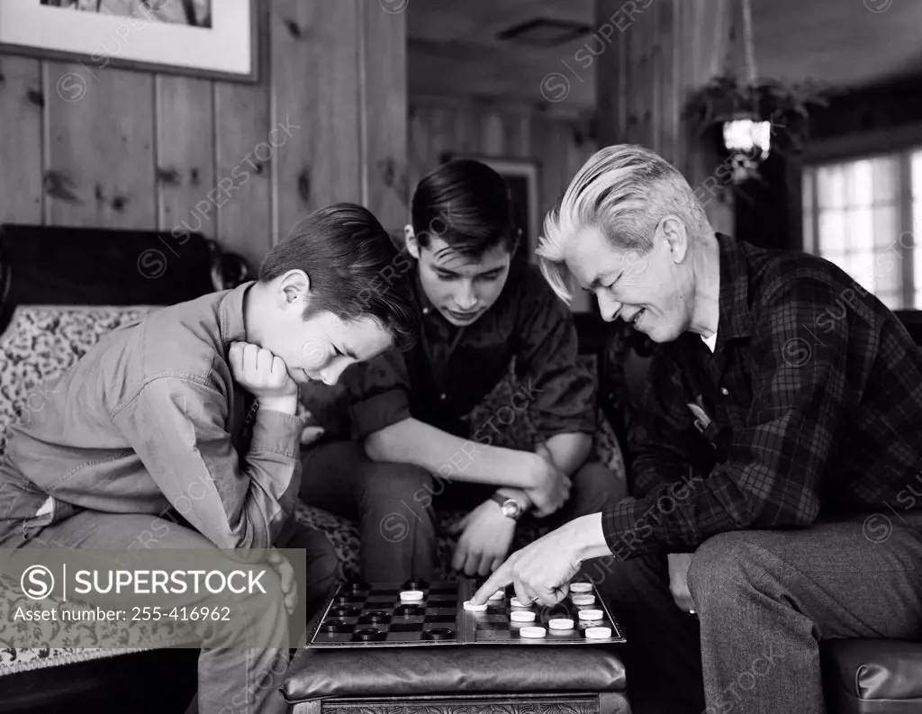 Father playing draughts with sons