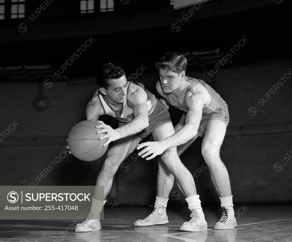Men playing basketball in gym