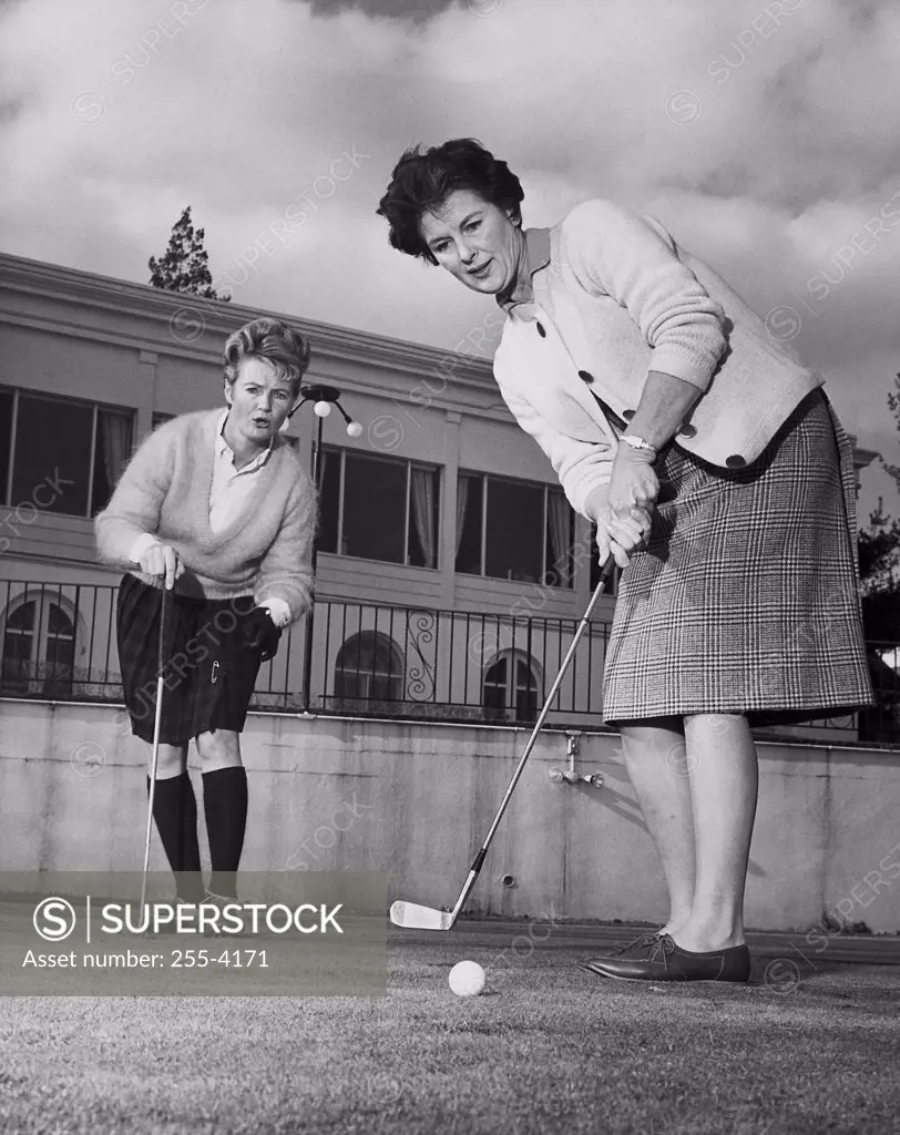 Two mature women playing golf