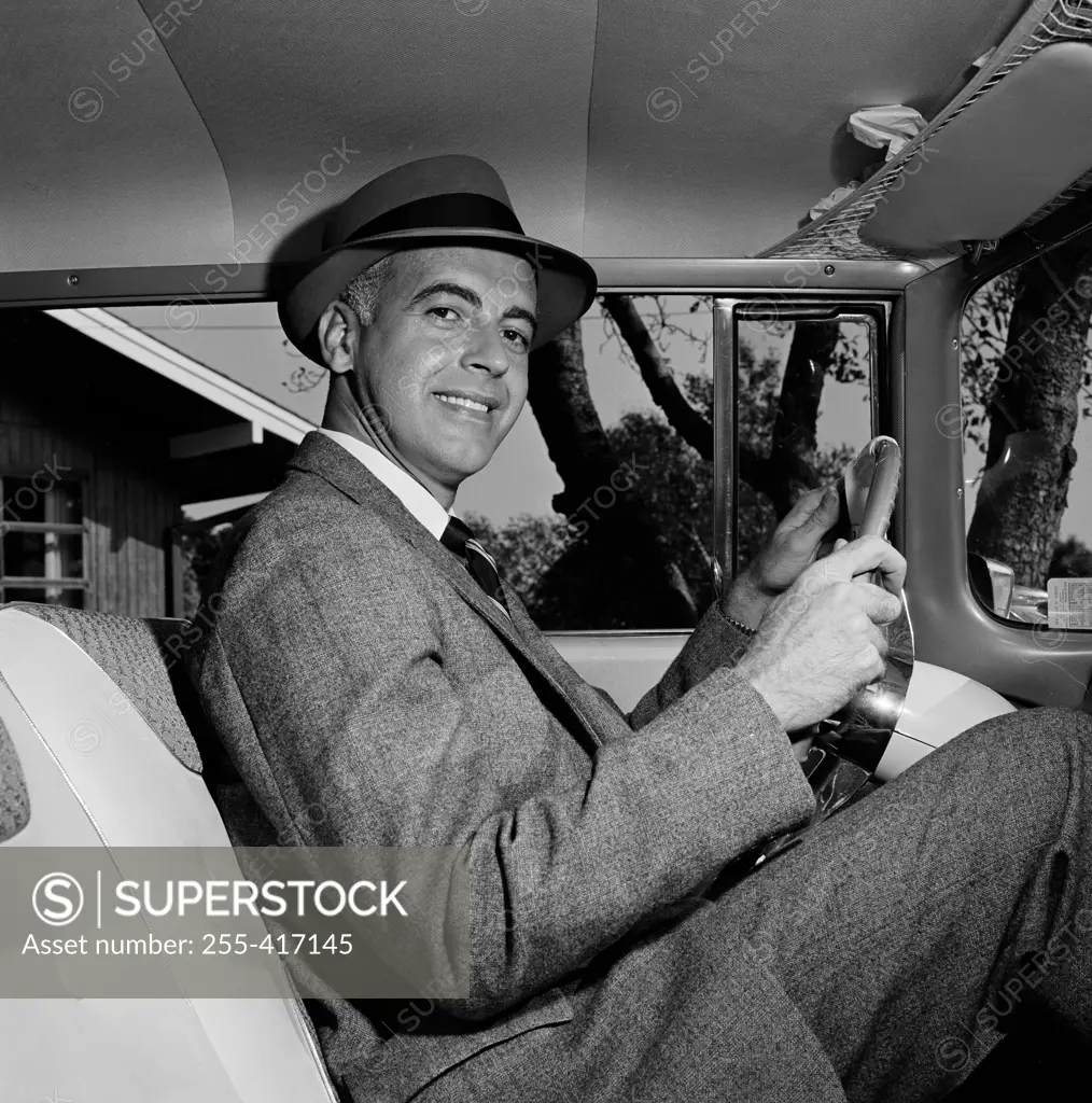 Confident mid-adult man sitting inside of car