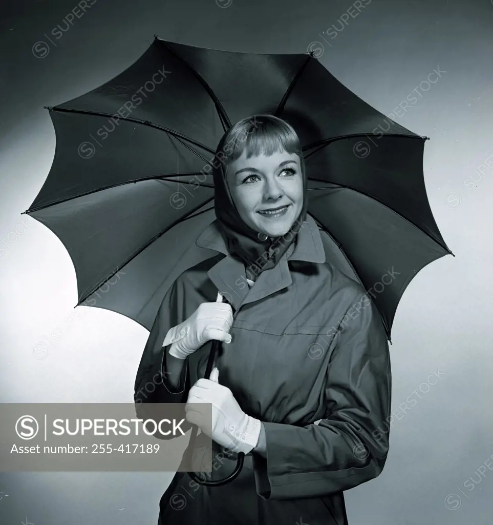 Studio portrait of smiling woman with umbrella