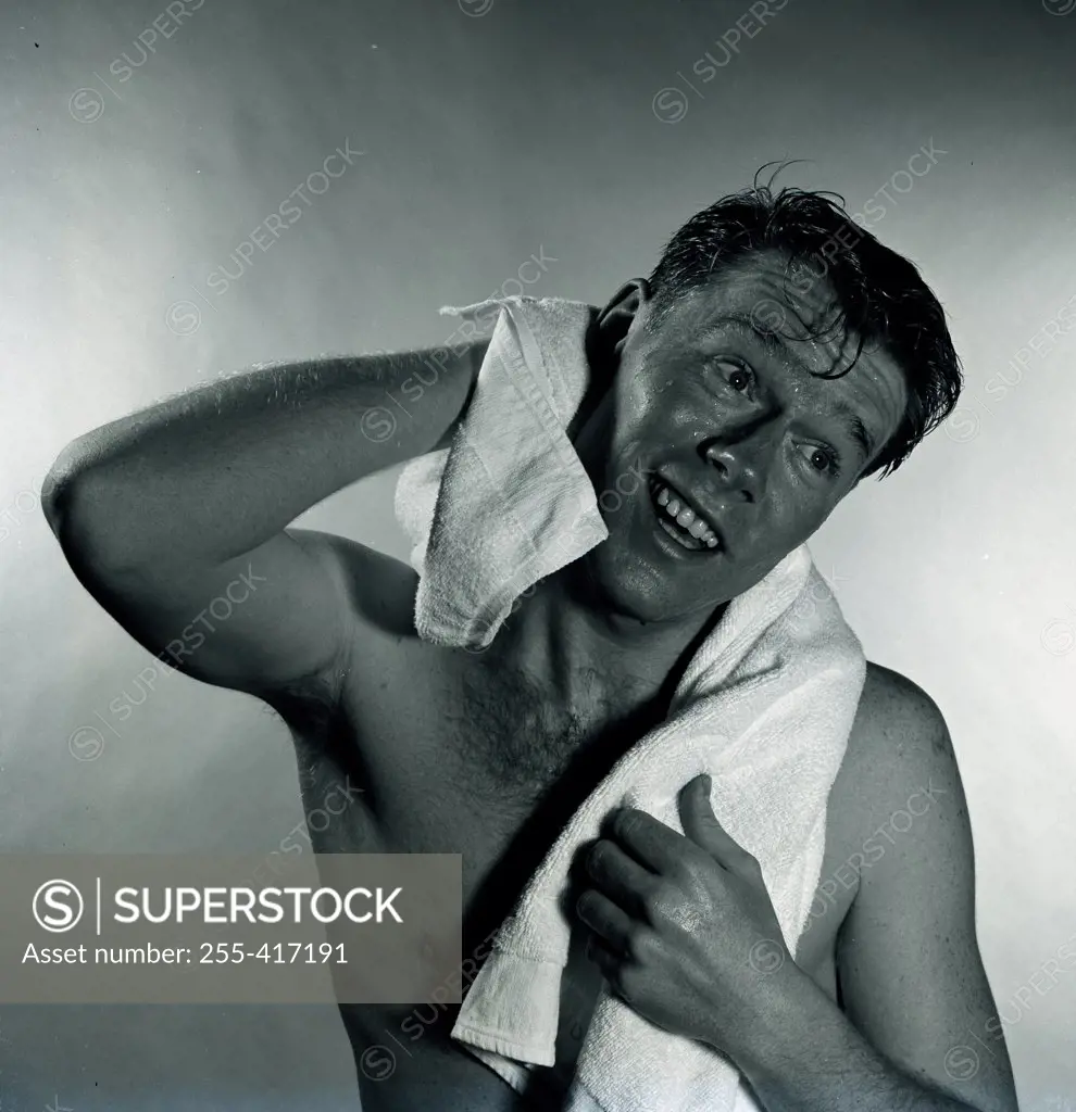Studio shot of man drying hair with towel