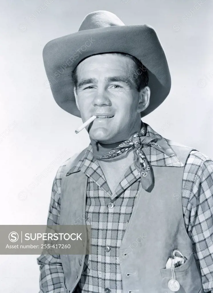 Studio portrait of cowboy smoking cigarette