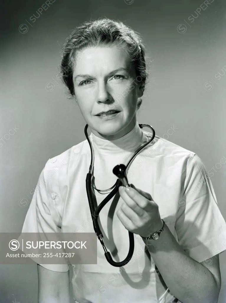 Studio portrait of female doctor holding stethoscope
