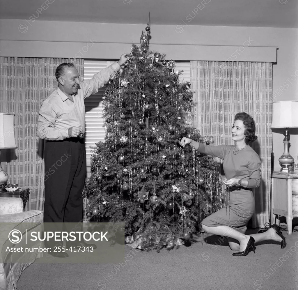 Mature couple decorating Christmas tree