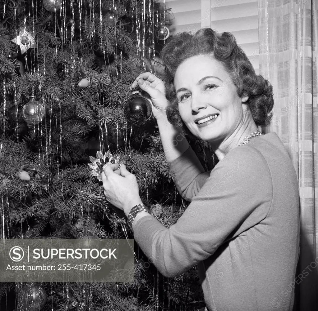 Mature woman decorating Christmas tree
