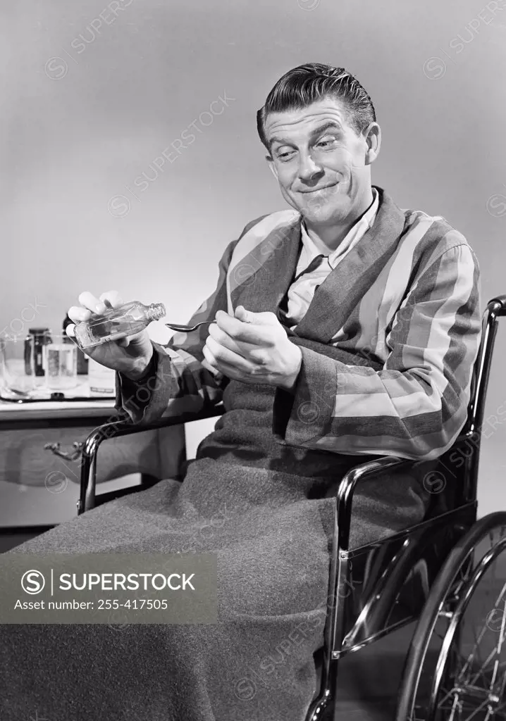 Man in wheelchair taking medicine