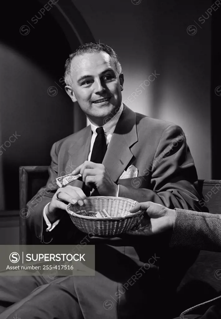 Man putting money into collection basket