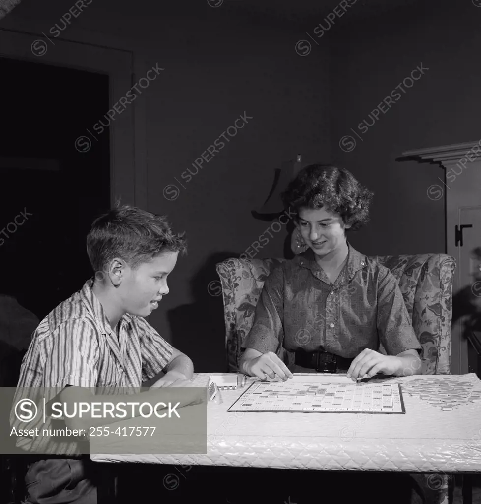 Mother playing scrabble with son in home