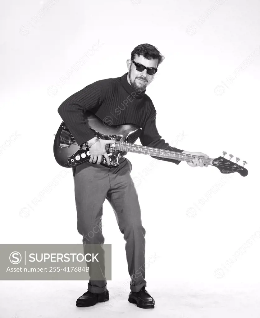 Portrait of young man playing base guitar