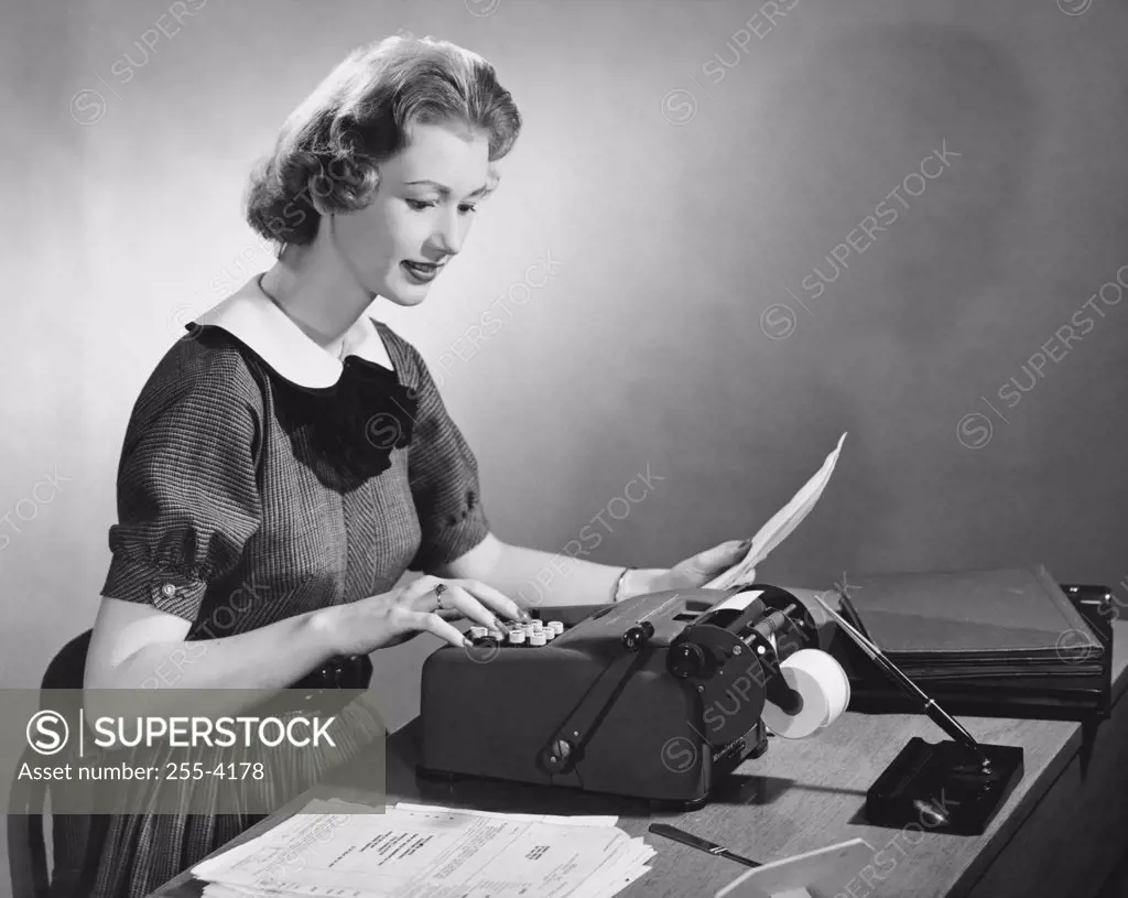 Businesswoman typing on a typewriter in an office