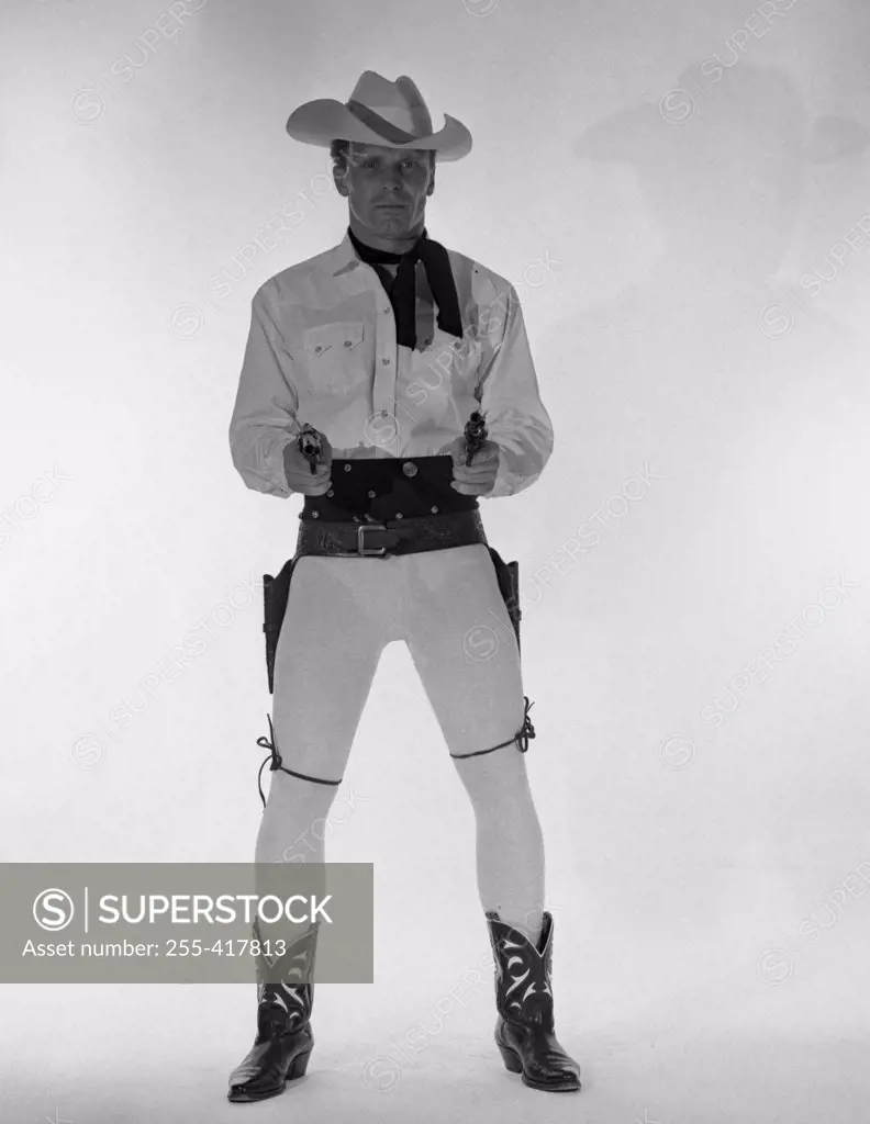 Mature cowboy holding guns