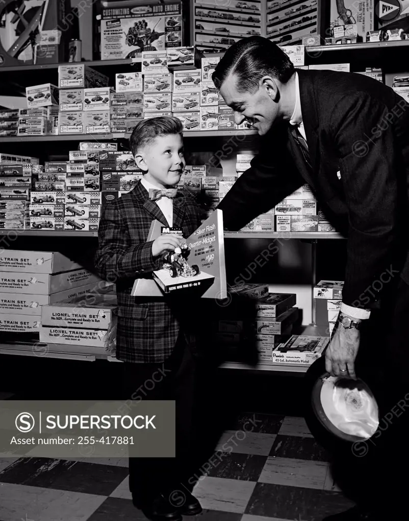 Shop assistant serving boy in toy shop
