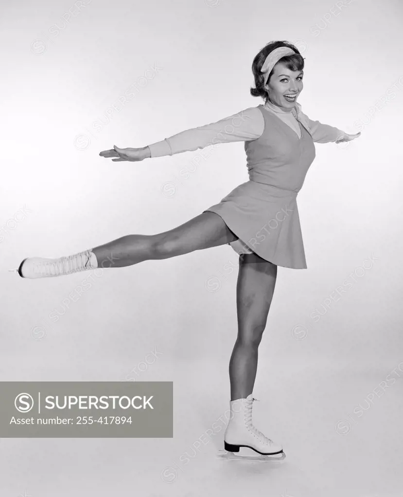 Studio portrait of young woman ice skating