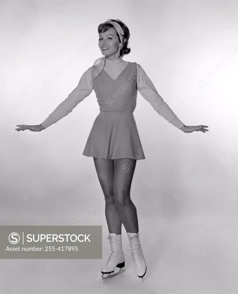 Studio portrait of young woman ice skating