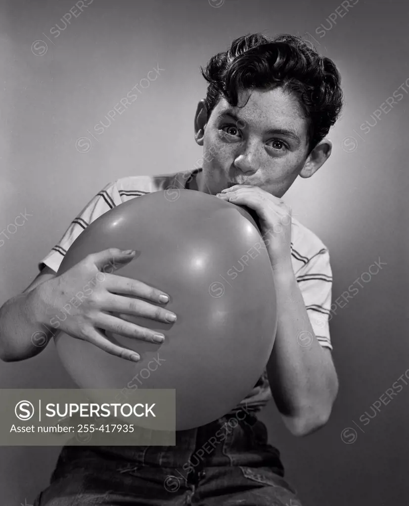 Boy blowing balloon