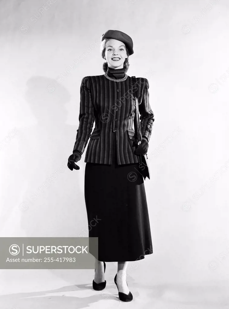 Mid adult woman wearing skirt, jacket and hat