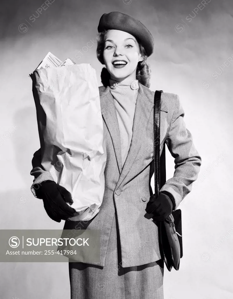 Mid adult woman holding shopping bag and smiling
