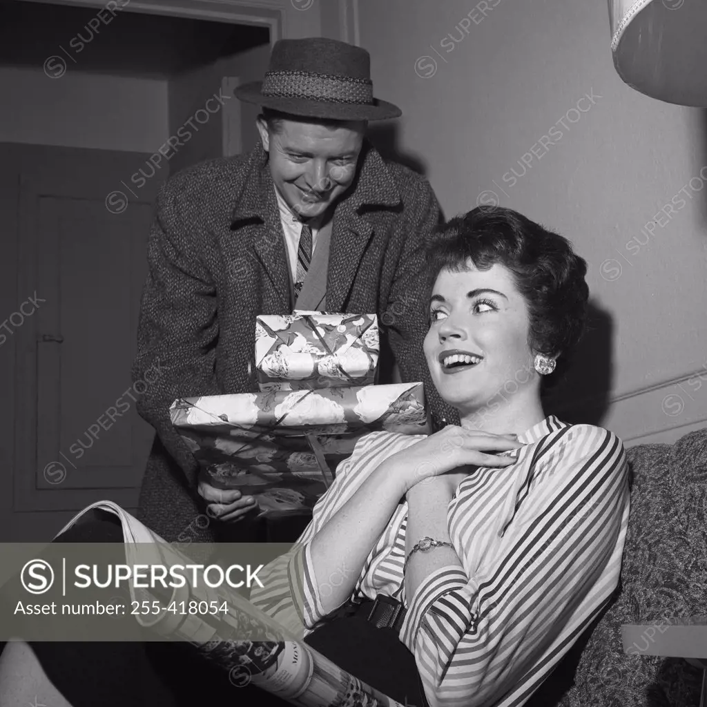 Young woman receiving presents from young man