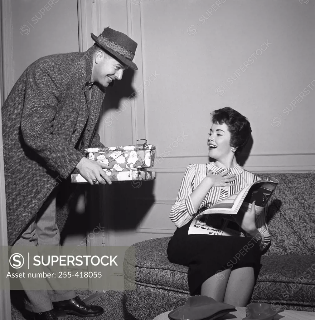 Young woman receiving presents from young man