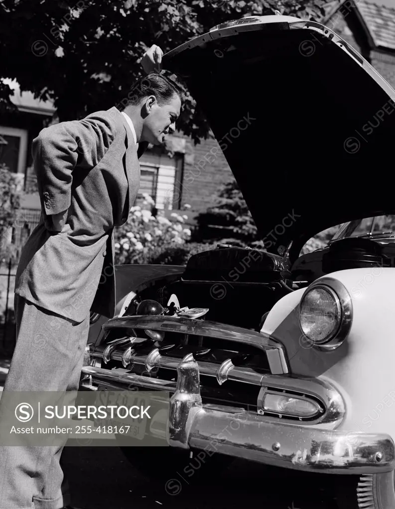Man looking into car hood