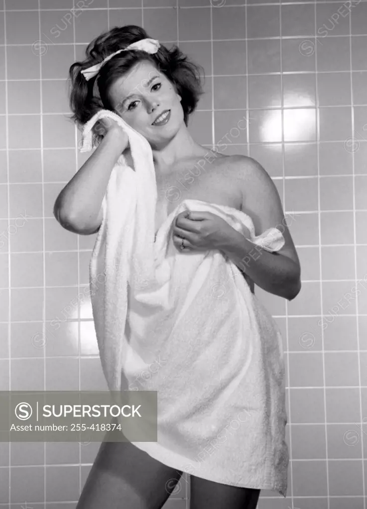 Portrait of young woman using towel in bathroom