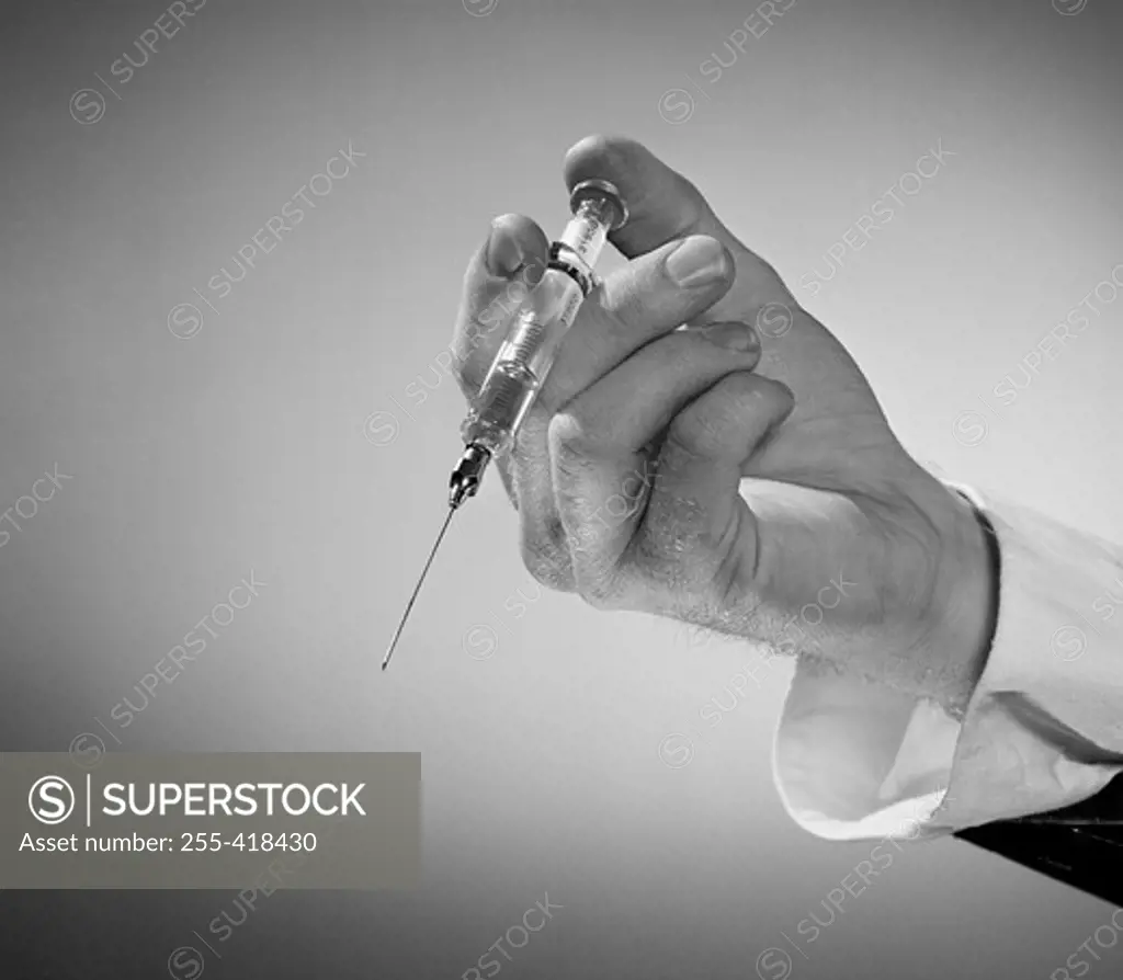 Man's hand holding syringe