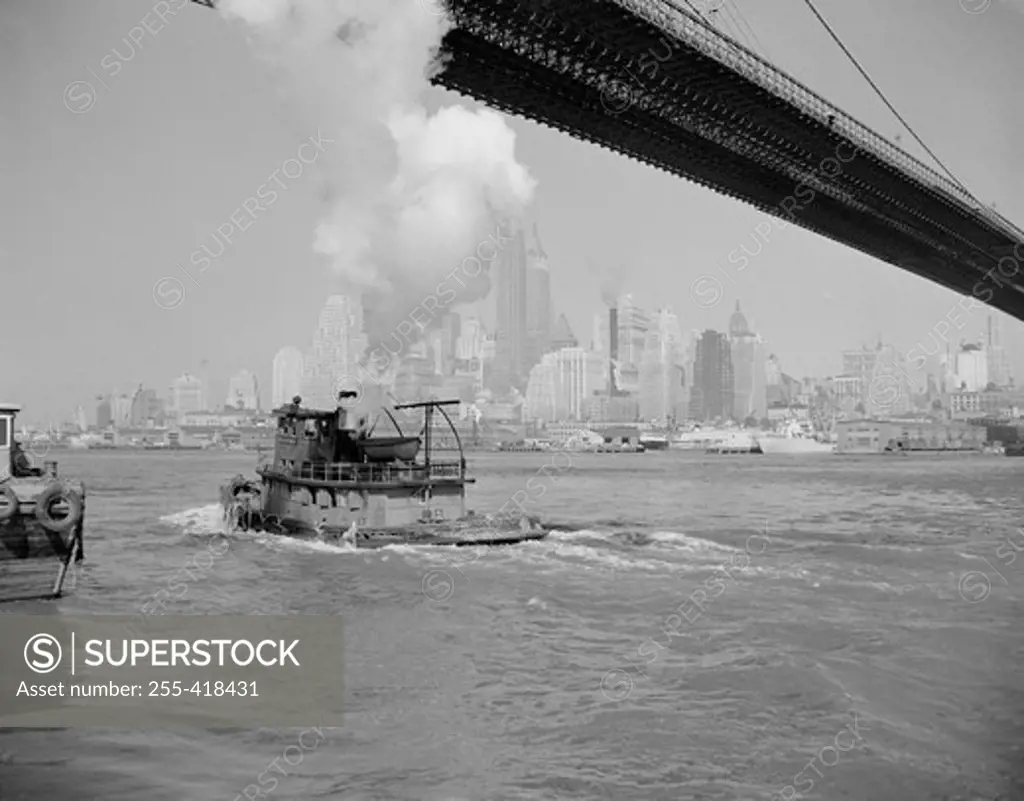 USA, new York State, New York City, Manhattan, Steamboat floating under bridge, skyline in the background