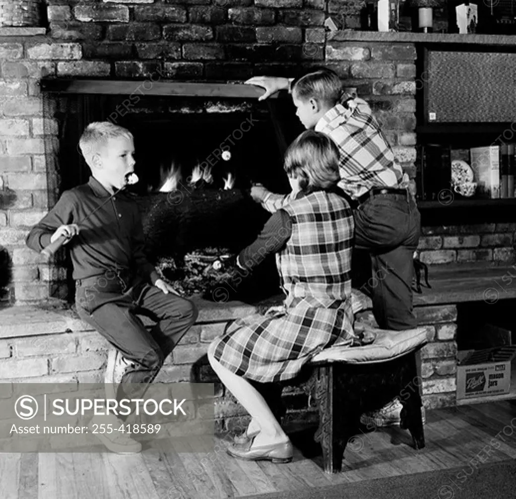 Girl and two boys in front of fireplace