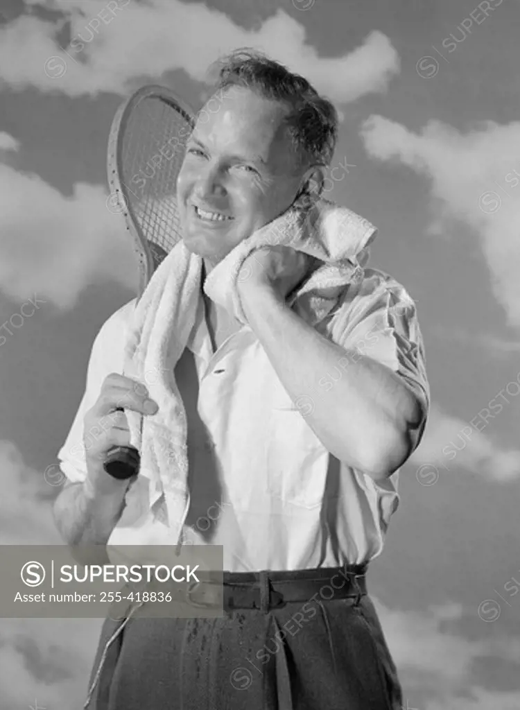 Portrait of male tennis player drying neck with towel