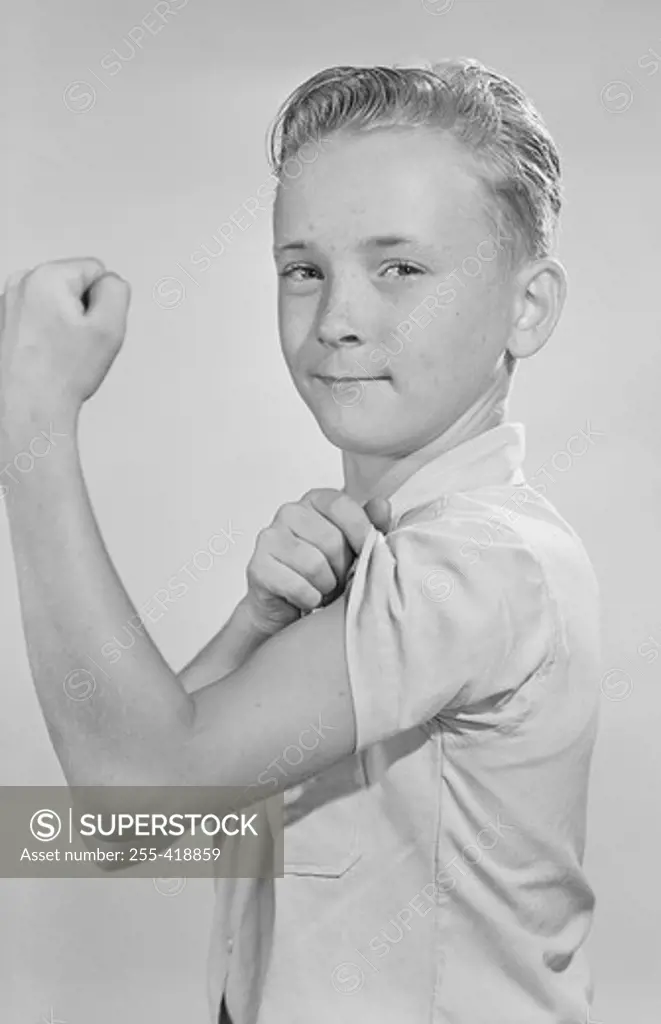 Portrait of boy showing off muscles