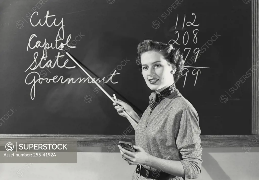 Vintage photograph. Teacher standing at chalkboard pointing to work