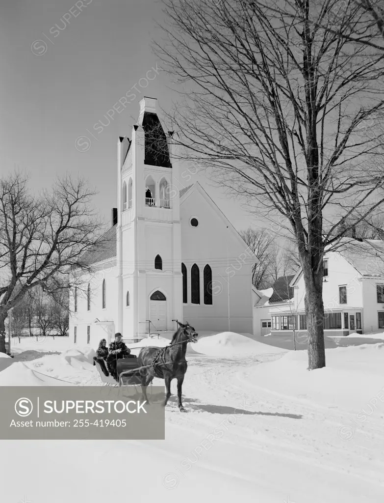 People on sleigh, church in the background