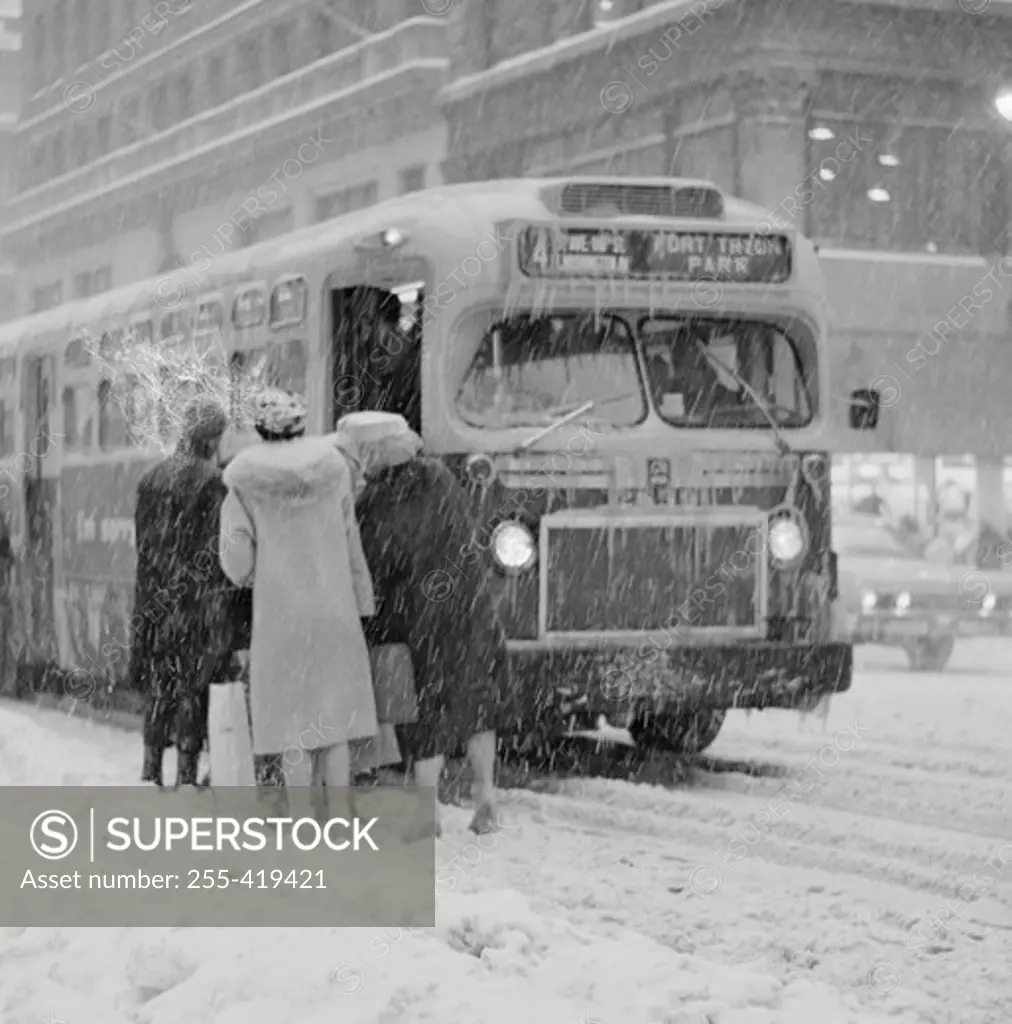 USA, New York State, New York City, People boarding bus on Fifth Avenue near 40th Street winter's day