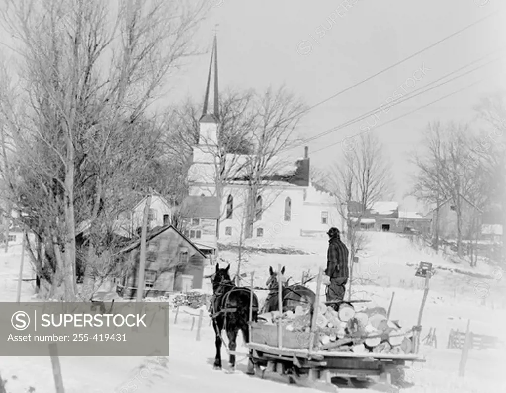 USA, Wisconsin, Irasburg, Winter scene with horse drawn sled, Catholic church in background