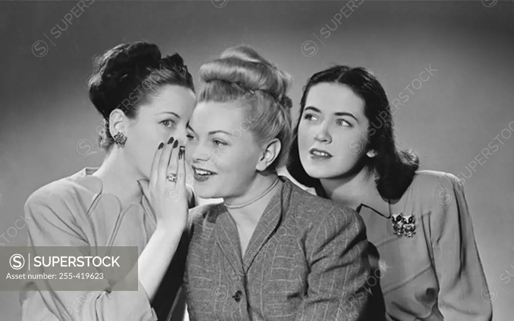 Portrait of three young women gossiping