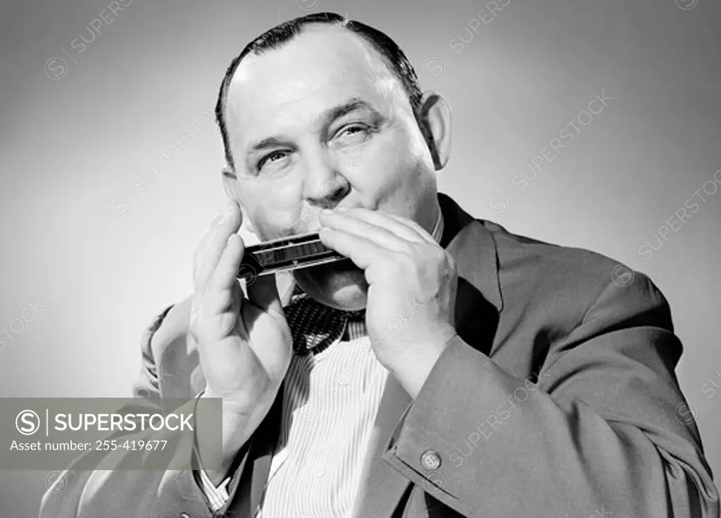 Portrait of man playing on harmonica