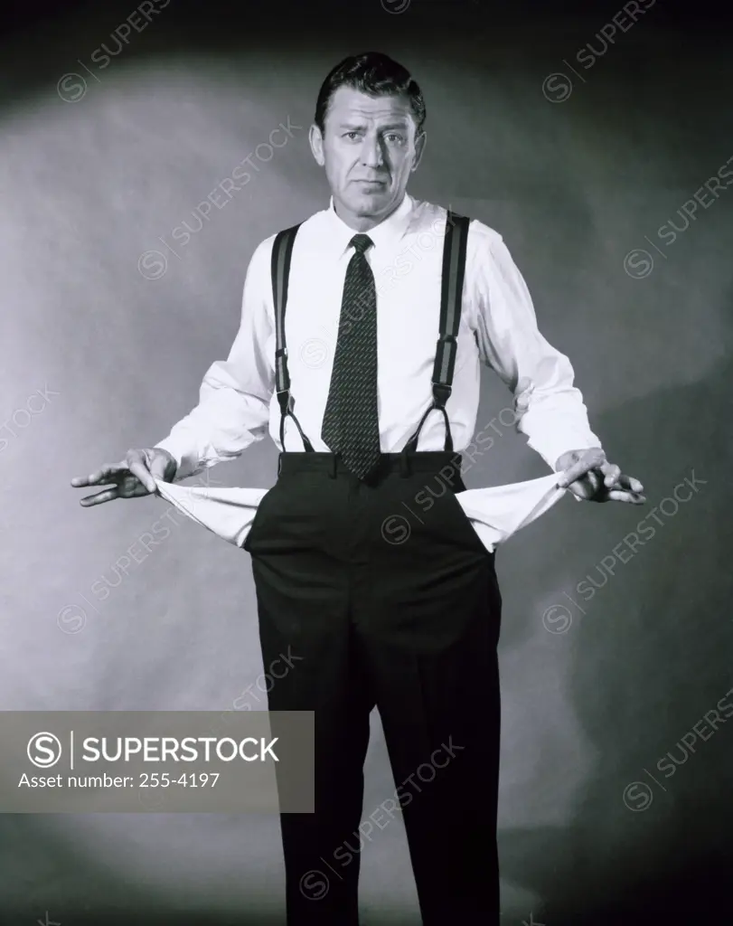 Portrait of a businessman showing his empty pockets