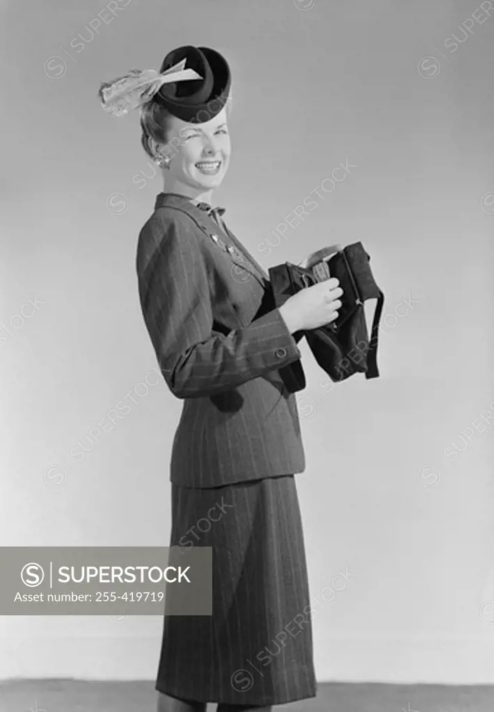Portrait of woman in hat, opening purse and winking
