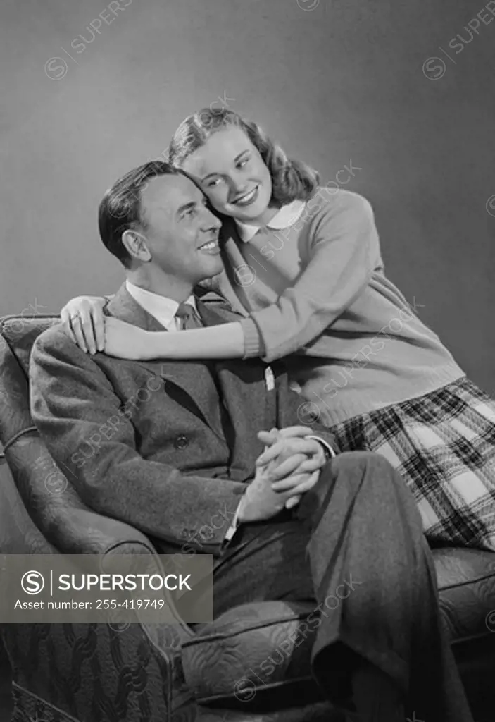 Portrait of father and daughter on armchair
