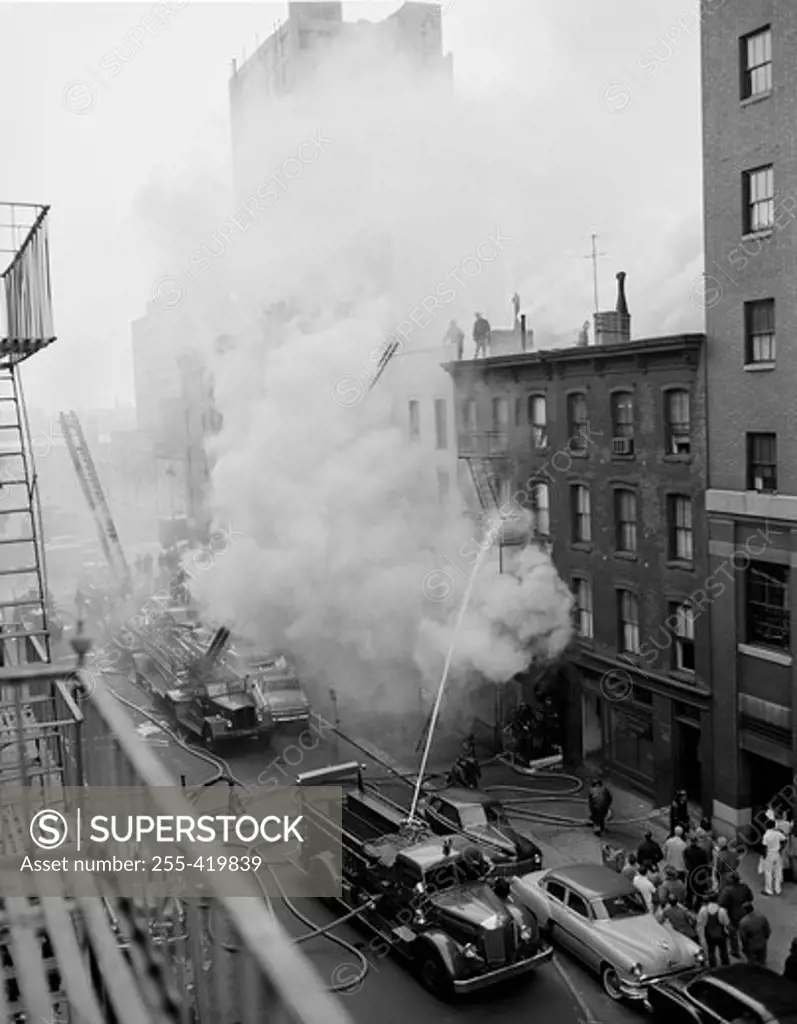 USA, New York State, New York City, Fire on East 47th Street, with fire engines shooting water on burning building